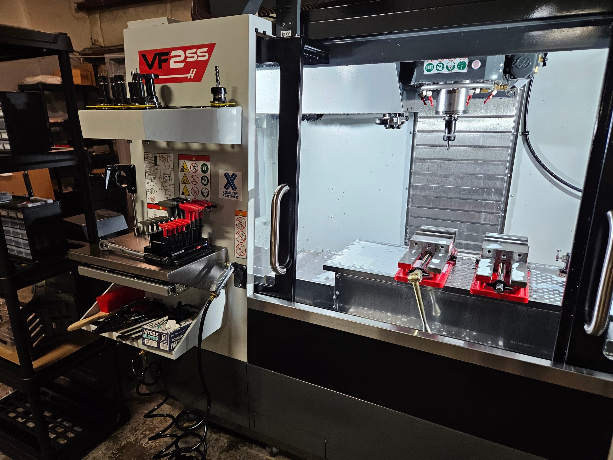 Cambian's Haas VF-2SS CNC machining center with tooling and vises staged on the shop floor